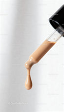 Close up of beige liquid foundation drop on applicator