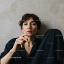 Young Woman with Short Hair and Pensive Expression in Casual Indoor Setting