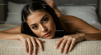 Young Woman Resting on Couch with Stylish Hair Clips and Natural Makeup