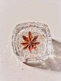 Star anise frozen inside a clear ice cube closeup