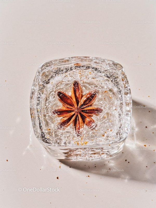 Star anise frozen inside a clear ice cube closeup