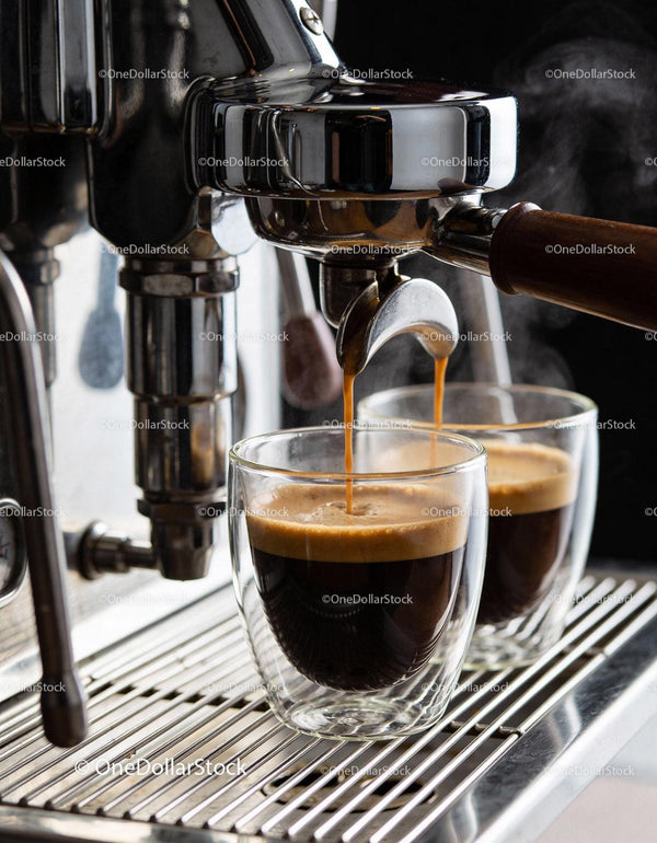 Freshly brewed espresso flows into double glass cups