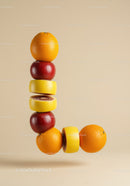 Creative fruit stack forming letter L on beige background