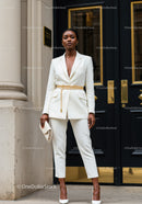 Confident woman in elegant white suit and gold belt
