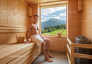 Relaxing Man in Wooden Sauna with Mountain View and Natural Light