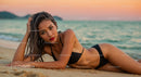 Glamorous Woman Relaxing on Beach at Sunset with Ocean View