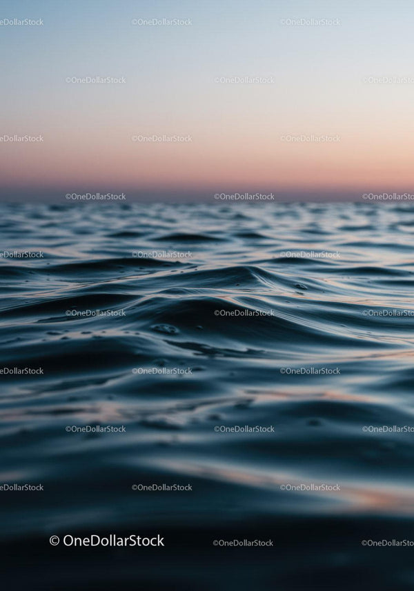 Spokojne fale oceanu o zachodzie słońca z łagodnym zmierzchem