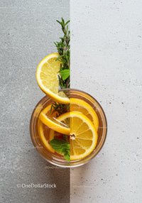 Refreshing lemon and herb iced tea on concrete surface