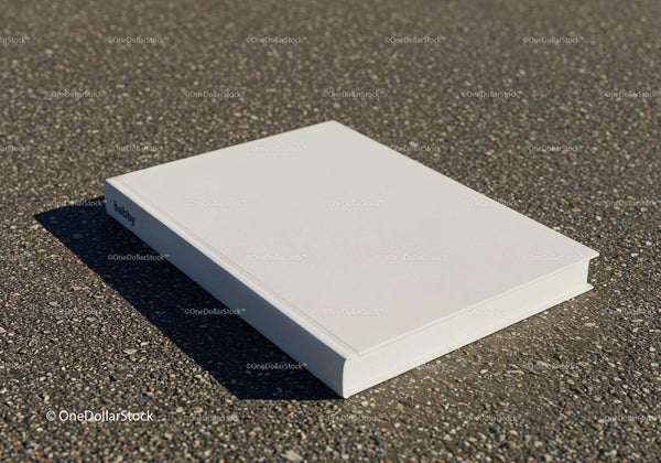 Closed white hardcover book lying on asphalt surface JPG Mockup Image