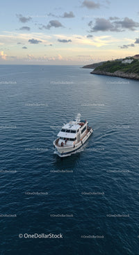 Luxury Yacht Sailing on Calm Blue Sea with Coastal Landscape