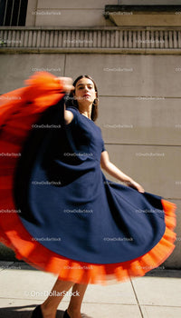 Woman spinning in chic navy dress with bright trim