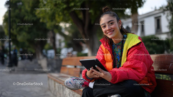 Smiling Woman Using Smartphone on Park Bench in Outdoor Setting