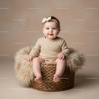Smiling baby girl sitting in a cozy woven basket