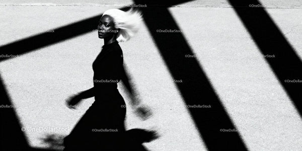 Silhouetted woman walking with dynamic white hair in sunlight