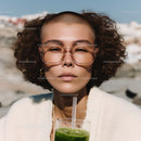 Fashionable Woman with Curly Hair and Green Smoothie Outdoors