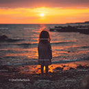 Silhouette of a Child at Sunset by the Ocean Shore
