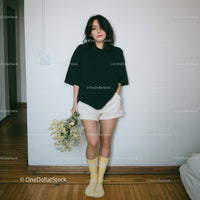 Young Woman in Casual Streetwear Holding Flower Bouquet Indoors