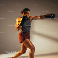 Female boxer training with focus and power indoors