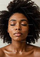 Close-up of a woman with curly hair wearing a facial mask