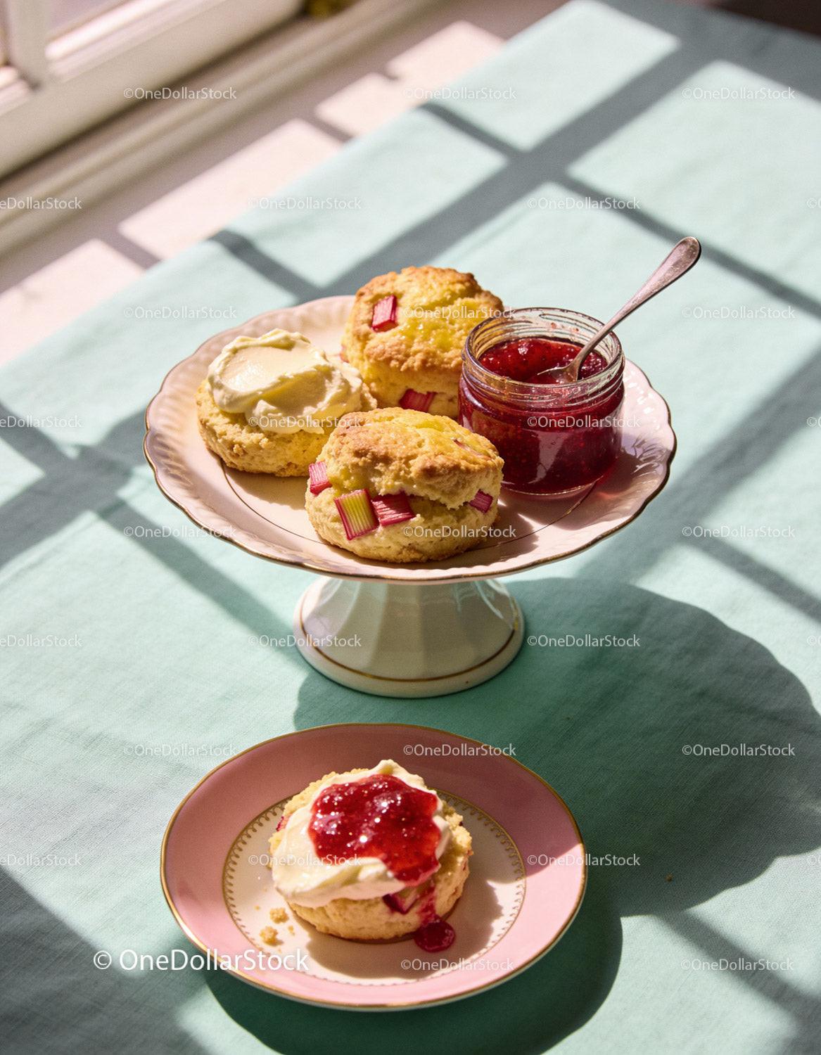 Homemade scones with cream and strawberry jam on plates
