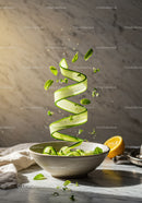 Fresh cucumber ribbons spiraling with mint leaves in bowl