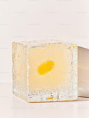 Transparent ice cube with yellow flower inside