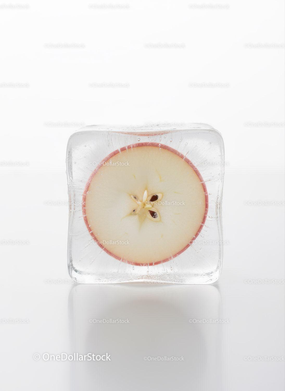 Fresh apple slice frozen in a clear ice cube