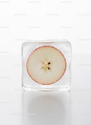 Fresh apple slice frozen in a clear ice cube