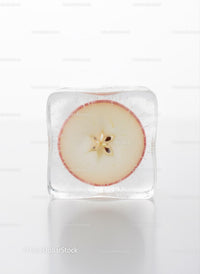 Fresh apple slice frozen in a clear ice cube