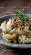 Close-up of Cooked Garlic Cloves with Herbs on a Rustic Plate