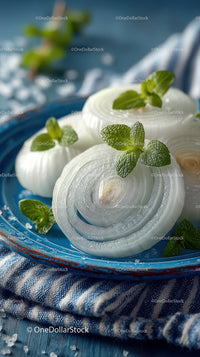 Fresh Onion Slices with Mint Leaves on Blue Ceramic Plate