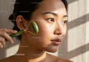 Elegant Woman Using Jade Roller for Skin Rejuvenation and Facial Care