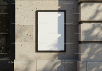 Minimalist blank poster on textured stone wall outdoors