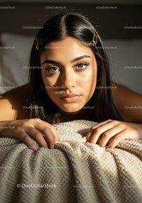 Young Woman with Long Dark Hair Relaxing on Beige Blanket in Natural Light