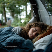 Peaceful Woman Resting in Sleeping Bag During Outdoor Forest Camp