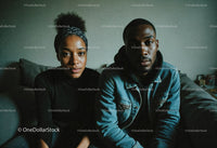 Young African American Couple Sitting on Couch in Casual Clothing