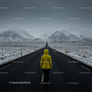 Lonely Traveler in Yellow Jacket on Snow-Covered Road