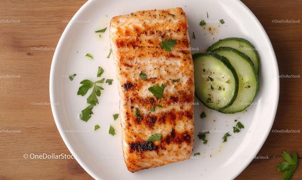 Grilled Salmon with Fresh Cucumber Slices and Herbs on White Plate