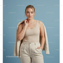Elegant woman in beige tank top and stylish beige trousers posing confidently