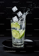 Refreshing lime slices splashing in sparkling water glass