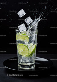 Refreshing lime slices splashing in sparkling water glass