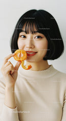 Young Woman Holding Mandarin Orange with Bright Smile