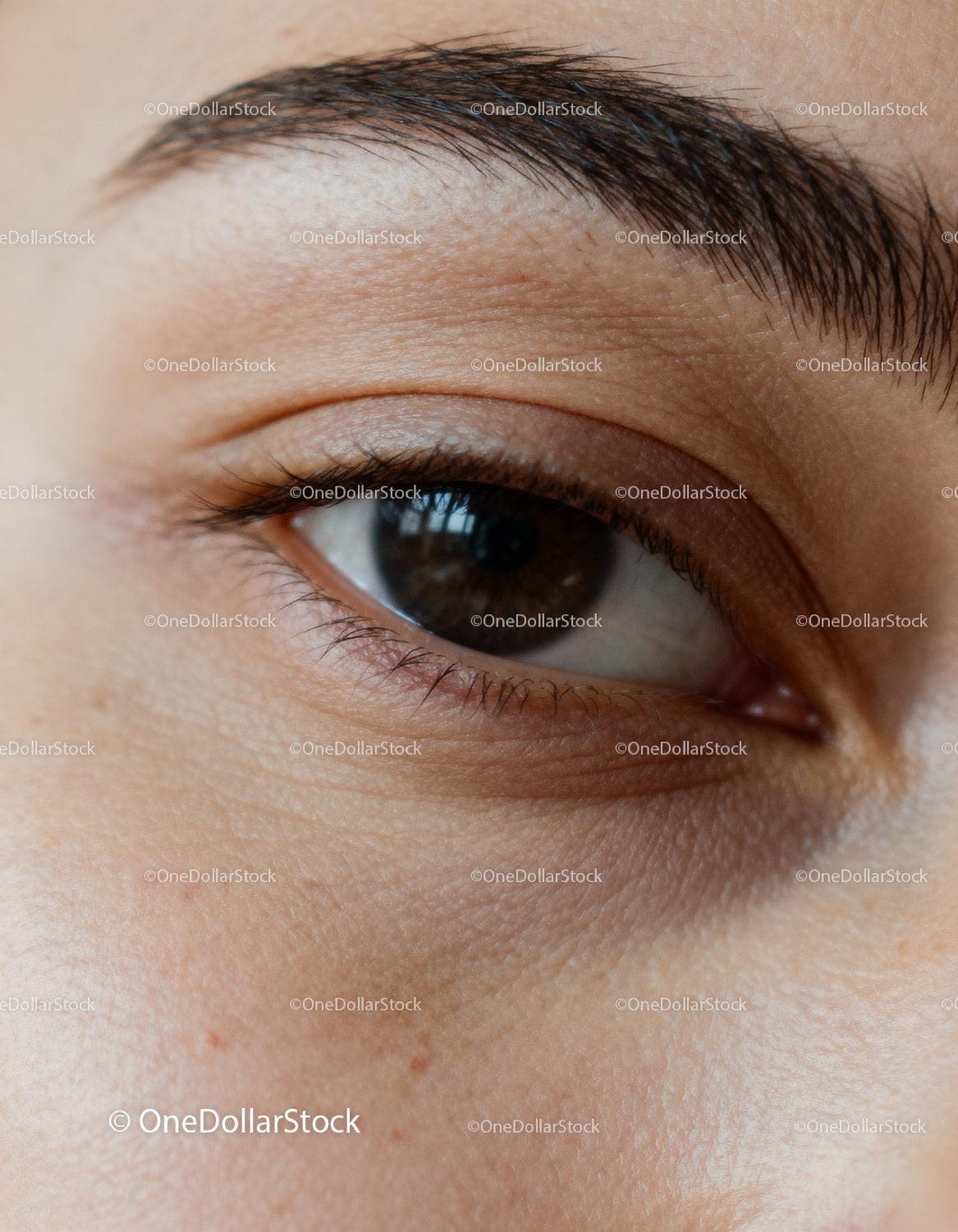 Close-up of natural brown eye with detailed skin texture