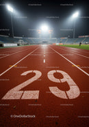 Empty illuminated running track lane at night stadium