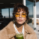 Fashionable Woman with Short Wavy Hair Wearing Yellow Sunglasses and Green Smoothie