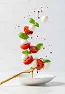 Fresh Caprese Salad Ingredients Suspended Above Plate