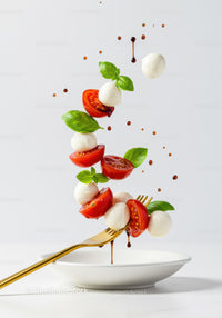 Fresh Caprese Salad Ingredients Suspended Above Plate