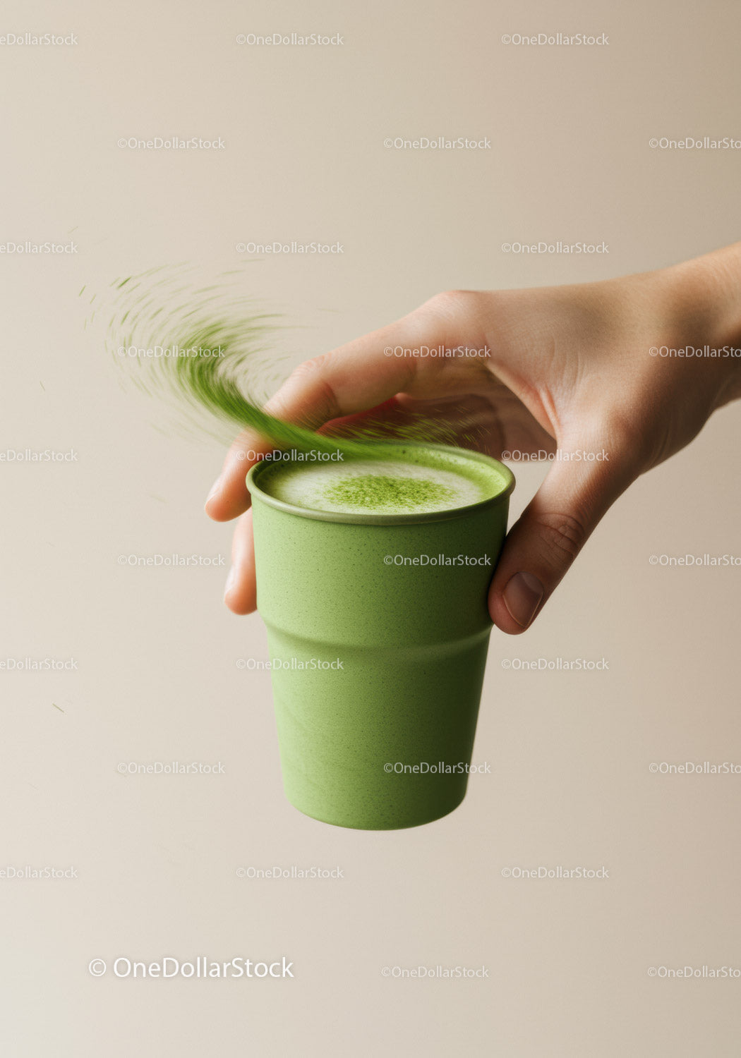 Hand Holding Green Matcha Latte in Minimalist Setting