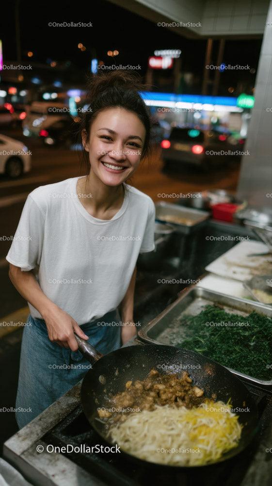 Young Female Chef Cooking Stir-Fried Noodles at Night Street Food Stall
