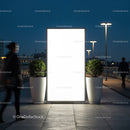 Illuminated urban billboard with pedestrians passing by